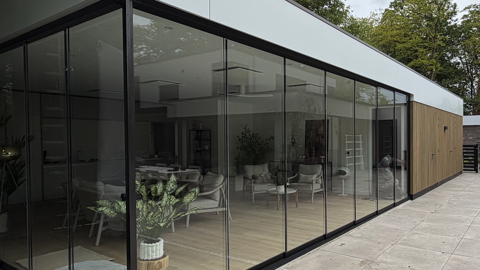 Poolhouse in Borger met een glazen hoek, verticale gevelbekleding en een ruim terras.